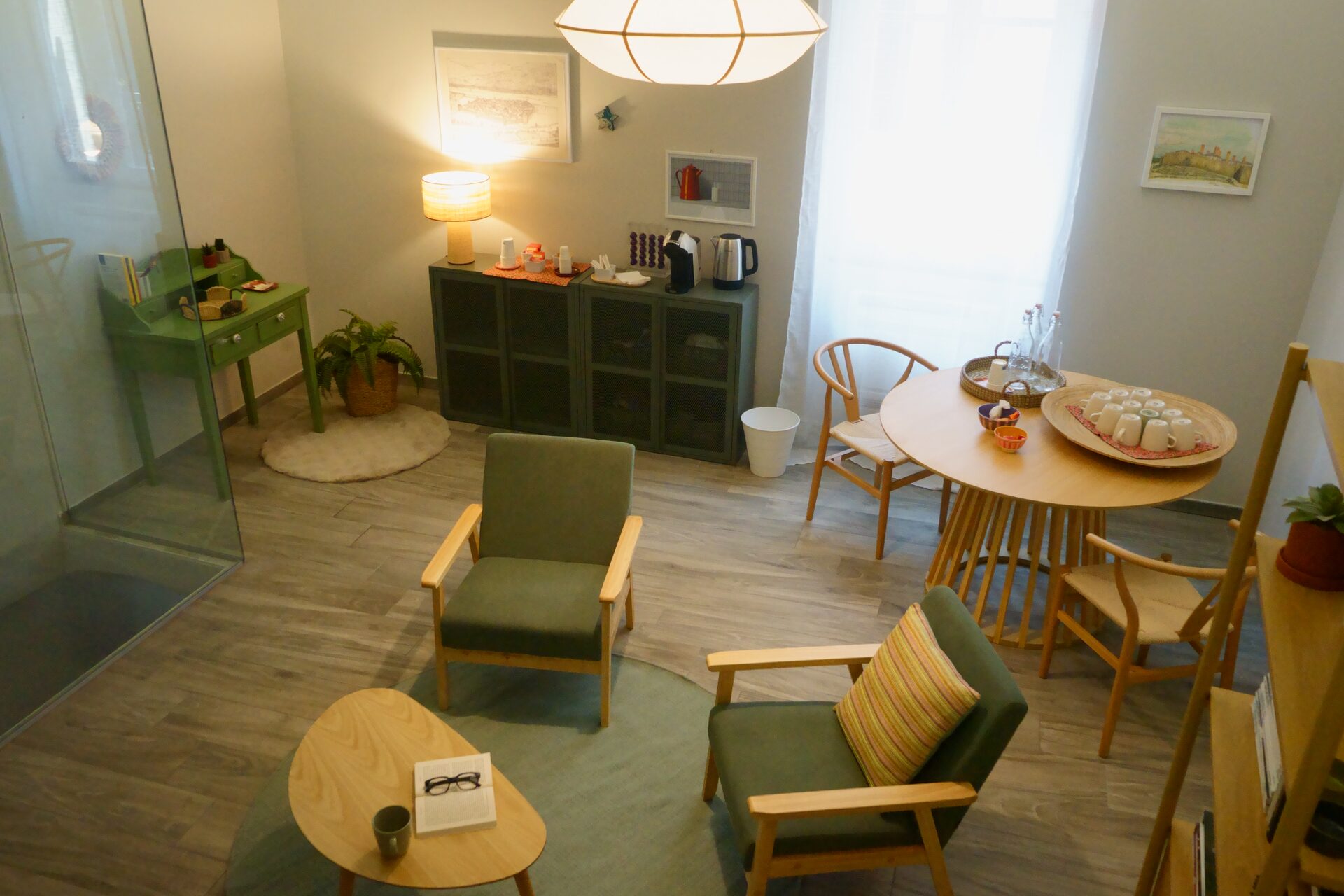 La living room con poltrone verdi e tavolo in legno